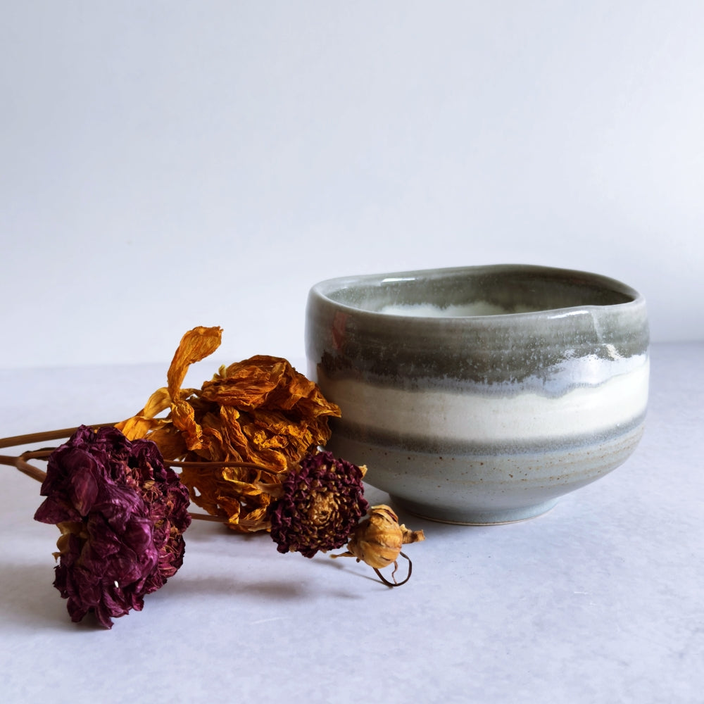 Ceramic bowl with dried flowers on a white background