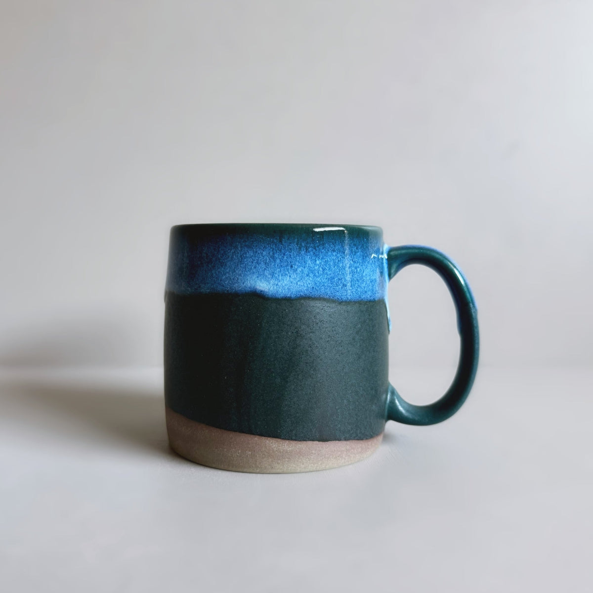 TOKA Japanese ceramic mug with a wavy glaze in dark blue and blue, handmade Mino ware from Gifu, Japan.