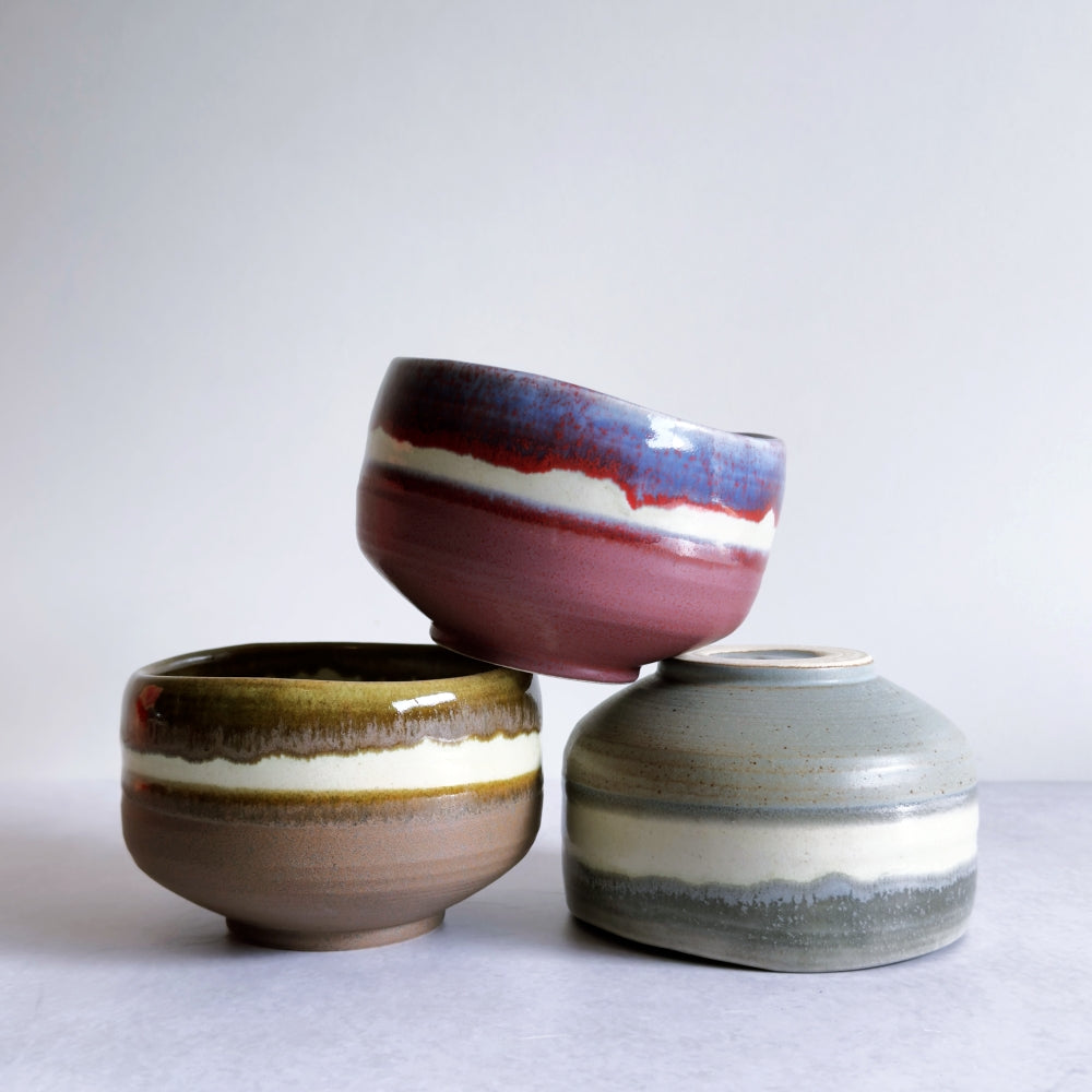 Three ceramic bowls with different color patterns on a white background