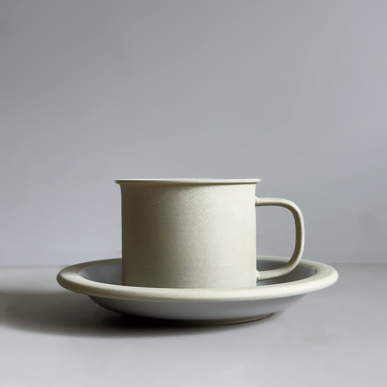 Ceramic cup and saucer on a light gray background