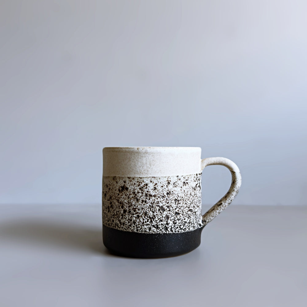 Japanese Mino Ware Ceramic mug with speckled design on a plain background.