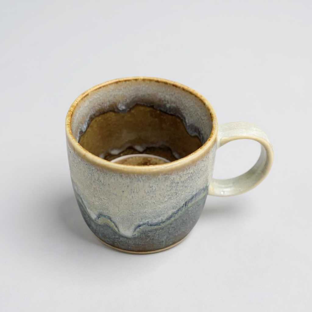 Inside of TOKA ceramic mug with a wavy reactive glaze in grey and cream, handmade Mino ware from Gifu, Japan