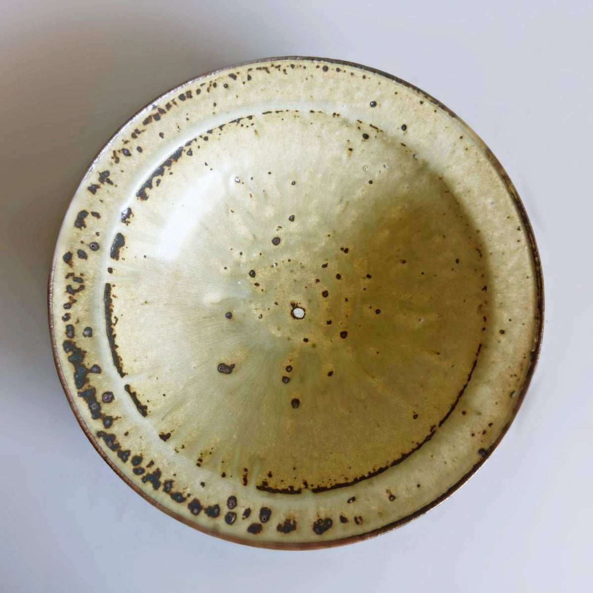 Top view of the bowl showing light olive glaze, brown speckles and a dark rim from Senju Living